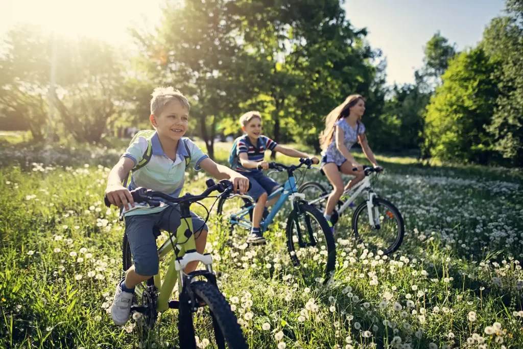 young kids on bikes riding in nature