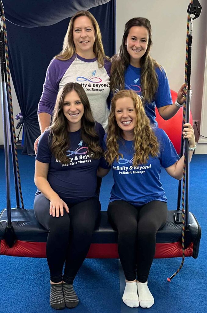 four female staff members posing in swing